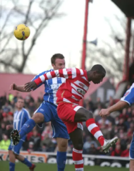 Buy Adam Hinshelwood in an aerial challenge with Jonathan Forte