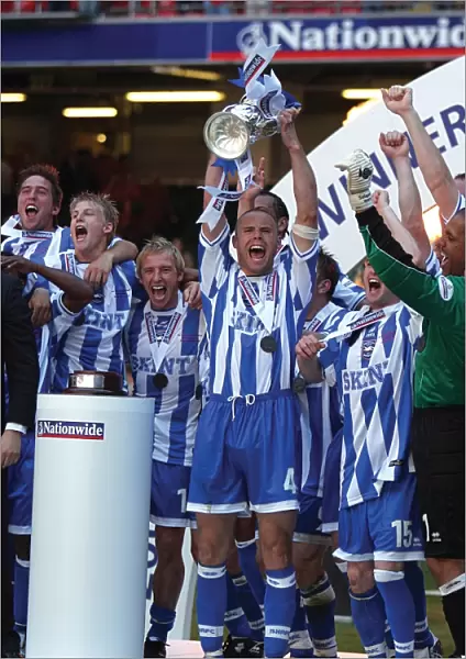Danny Cullip lifts the play-off trophy at the Milennium Stadium, Cardiff