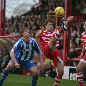 Alex Revell watches Graeme Lee clear the ball